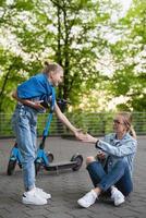 mutter und tochter nach elektrorollerfahrt im stadtpark foto