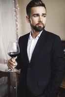 hübscher bärtiger mann mit einem glas rotwein foto