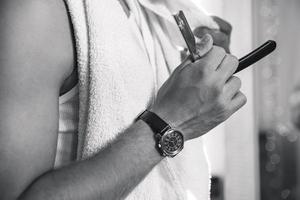 Mann rasiert seinen Bart mit einem Rasiermesser foto