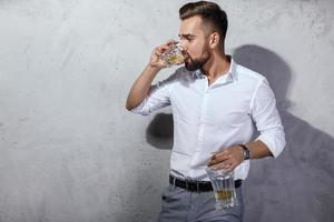 hübscher bärtiger mann mit einem glas whisky foto