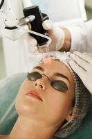 arzt dermatologe und klientin während der laserbehandlung der hauterneuerung foto