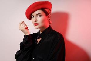 Porträt der jungen schönen Frau mit roter Baskenmütze foto