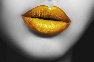 Nahaufnahme der weiblichen Lippen mit goldenem Lippenstift foto