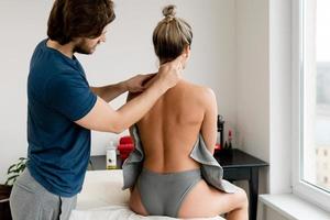 Professioneller Masseur, der Akupressurtechniken für die Nackenmassage des Kunden anwendet foto