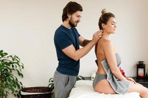 Professioneller Masseur, der Akupressurtechniken für die Nackenmassage des Kunden anwendet foto