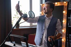 Der junge Musiker macht ein Selfie in einem Studio foto