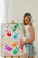 junge frau, die mit ihren handflächen mit bunten regenbogenfarben zeichnet, um die lgbt-gemeinschaft zu unterstützen foto