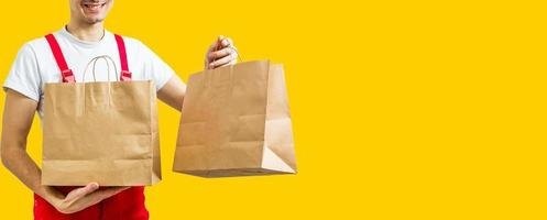 lieferservice, fast food und personenkonzept - glücklicher mann mit kaffee und einwegpapiertüten gelber hintergrund foto