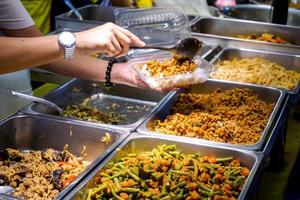 Nahaufnahme verschiedener veganer chinesischer Lebensmittel, die auf dem Lebensmittelmarkt verkauft werden, um das chinesische Neujahrsfest 2020 mit der Hand des Händlers zu begrüßen, der Lebensmittel an Kunden verkauft. foto