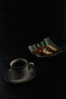 Tee und Kuchen auf schwarzem Hintergrund. teezeit zu hause konzept. foto