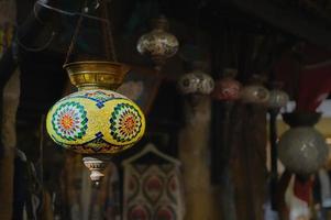 türkei, ein markt mit traditionellen farbenfrohen handgefertigten türkischen lampen und laternen, selektiver fokus auf eine laterne, unscharfer hintergrund, laternen, die in einem geschäft zum verkauf hängen. beliebte Souvenirs foto
