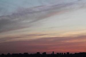 bunte bewölkte Dämmerung schöner Himmel Stadtbild Sonnenuntergang und Sonnenaufgang am Morgen. dramatische Abendnacht am frühen Morgen mit Silhouette der Stadtgebäude. Panorama-Hintergrundkonzept. Platz für Text kopieren foto