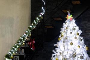 weihnachtsbaum mit weihnachtsschmuck im innenraum mit eleganter treppe foto