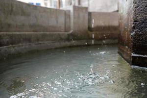 Wassertropfen in einem alten europäischen Trockenbrunnen aus Stein foto