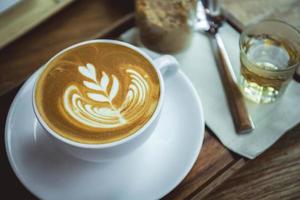 Kaffee-Aroma-Latte-Tasse im Holztisch-Café-Stil foto