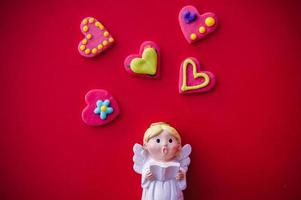 Amor-Puppe und herzförmig auf rotem Hintergrund foto