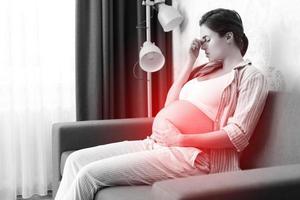 junge schwangere frau hat schmerzhafte kopfschmerzen foto