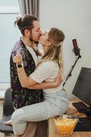junges Paar küsst sich auf dem Tisch mit Gaming-PC foto