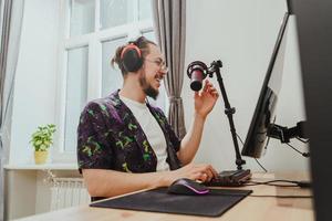 junger Blogger mit Kopfhörern und Kondensatormikrofon während des Online-Podcast-Streams foto