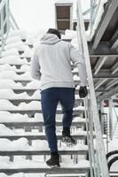athletischer mann, der während seines wintertrainings auf treppen läuft foto