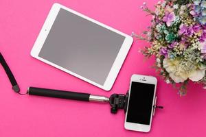 Smartphone auf einem Selfie-Stick und Tablet-PC foto