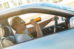 Mann trinkt Bier in seinem Auto foto