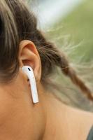 Nahaufnahme des weiblichen Ohrs mit drahtlosem Ohrhörer foto
