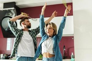 Paar tanzt in der Küche beim Kochen am sonnigen Morgen foto