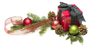 Weihnachtsgeschenk mit Band, Tannenzapfen und Ornamenten foto