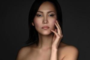 Porträt einer jungen und schönen Asiatin auf grauem Hintergrund foto