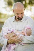 Junger hübscher Vater hält sein neugeborenes Mädchen foto