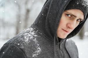 Schöner sportlicher Mann mit Hoodie während seines Wintertrainings foto