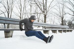 athletischer Mann, der während seines Calisthenics-Wintertrainings Liegestütze macht foto