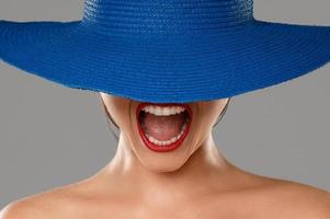 Porträt eines fremden Mädchens mit roten Lippen und blauem Hut foto