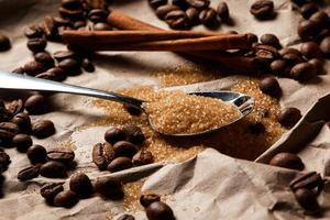 Löffel mit braunem Zucker und Kaffeebohnen foto