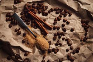 Löffel mit braunem Zucker und Kaffeebohnen foto