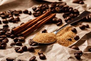 Löffel mit braunem Zucker und Kaffeebohnen foto