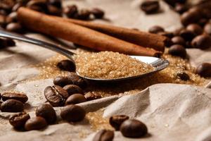 Löffel mit braunem Zucker und Kaffeebohnen foto