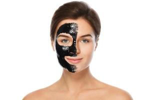 schöne Frau mit einer schwarzen Reinigungsmaske im Gesicht foto