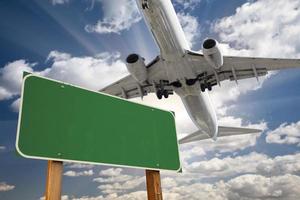 leeres grünes Straßenschild und Flugzeug oben foto