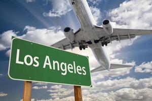 grünes straßenschild los angeles und flugzeug oben foto