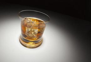 Glas Whiskey und Eis unter Scheinwerferlicht foto