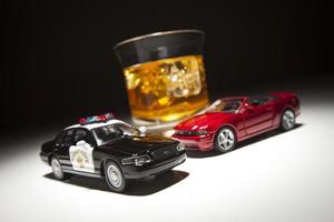 Polizei und Sportwagen neben alkoholischem Getränk foto