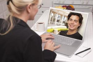 Frau in der Küche mit Laptop Online-Dating-Suche foto