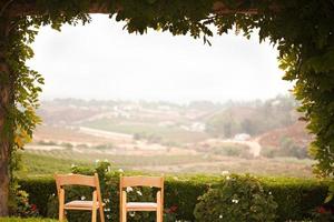 Wein bedeckte Terrasse und Stühle mit Blick auf das Land foto