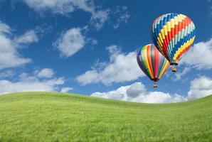 Heißluftballons im wunderschönen blauen Himmel über der Wiese foto