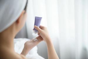 Nahaufnahme von Frauen, die Bodylotion-Creme auf die Hand auftragen. foto