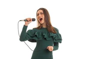 schöne frau singt im mikrofon ein karaoke im grünen kleid foto