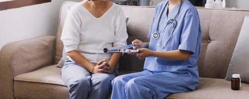 Homecare Pflegedienst und Kardiologie für ältere Menschen Gesundheitswesen. Nahaufnahme einer jungen hispanischen Ärztin, die während des Besuchs den Herzschlag eines reifen kaukasischen Mannes mit einem Stethoskop überprüft foto