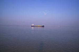 Landschaftsansicht eines kleinen Frachtschiffs vor blauem Himmel auf dem Fluss Padma in Bangladesch foto